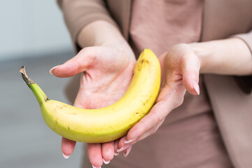 Fresh banana in a female hand isolated on white