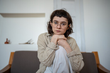 Apathetical teenager in deep thoughts, looking at camera with indifferent glance, feeling...