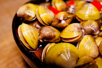a bowl of clams marinated in soy sauce and chili