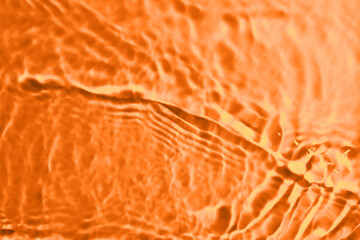 Rippled surface of clear water on orange background