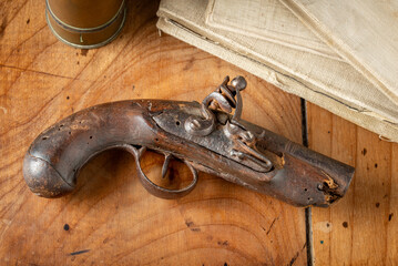 Antique wooden and metallic pistolet on an old wooden table