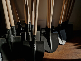 logistics center with lots of shovels ready for workers and sales. wooden handles and sheet...