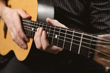 Playing acoustic guitar. The musician holds a musical instrument in his hands. Close-up. Soft focus.