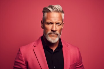 Portrait of a serious mature man in a pink suit. Men's beauty, fashion.