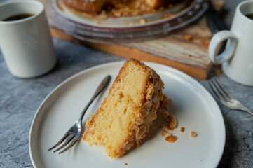 Slice of butter cake with almond, sugar topping on a plate