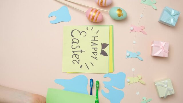 Dental Easter with hands, teeth figurines and postcard with Happy Easter text.