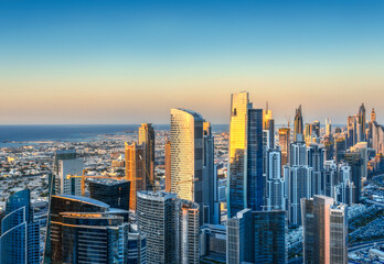 Modern city architecure at sunset. Elevated view of Dubai's business bay towers.