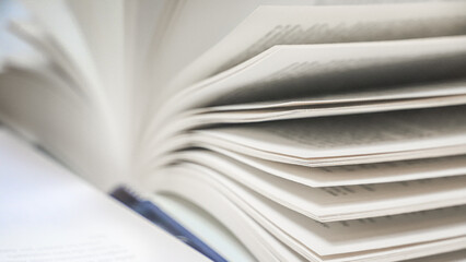 stack of books, close up. Open book on the table in library. Back to school concept. Open book on table with blur bookshelf background