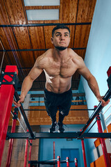 Muscular, athletic young man with relief strong body, training shirtless in gym, doing push ups...