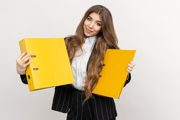 A businesswoman poses with yellow folders in her hand, signalling her attention to detail and...