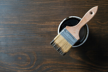 Top view on paint brush on the opened can on wooden table background or floor painting and...