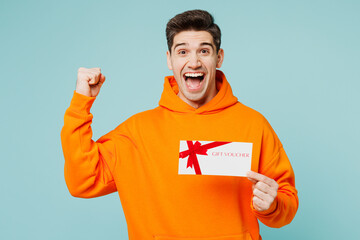 Young man wears orange hoody casual clothes hold gift certificate coupon voucher card for store do...