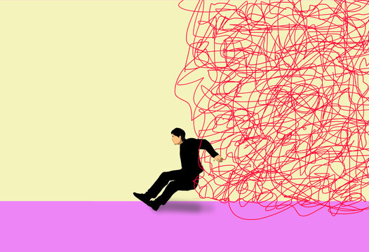 Man struggling to hold back large tangled strings