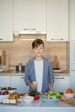 Smiling boy standing in kitchen at home