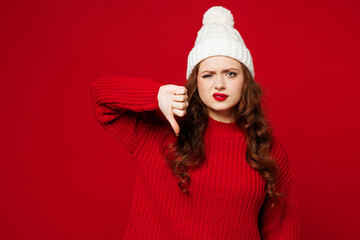 Young dissatisfied upset sad Caucasian woman wear knitted sweater white hat casual clothes showing...