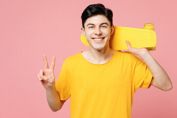 Young smiling Caucasian man he wears yellow t-shirt casual clothes hold on shoulder skateboard...