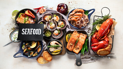 Set of Seafood dishes on light wooden background.