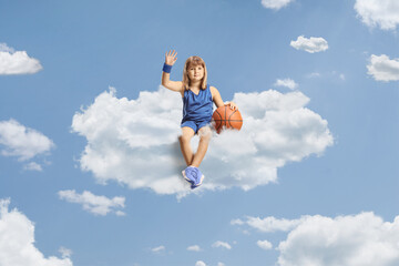 Little girl with a basketball sitting on a cloud
