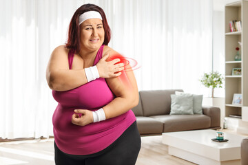 Fototapeta na wymiar Plus size woman with a red inflamed shoulder at home
