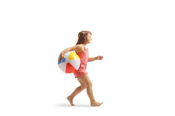 Fototapeta na wymiar Full length profile shot of a girl running with a beach ball
