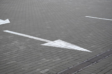 white arrow on gray asphalt, turn left, turn right, abstract white lines on asphalt, background of...