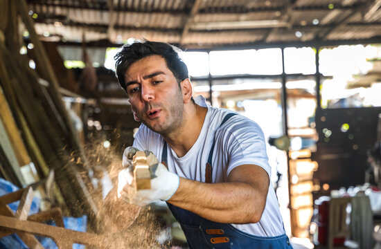Portrait of Caucasian carpenter blowing sawdust in carpentry wood workshop