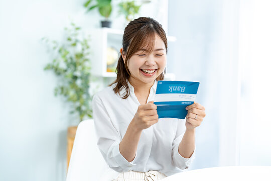 笑顔で通帳を持つ日本人女性