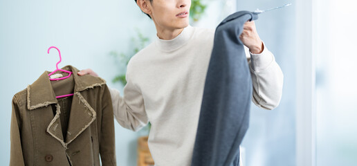 服を選ぶのに迷う男性