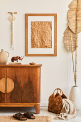 Minimalist composition of living room with brown mock up picture frame, carpet, macrame, dried tropical leaf, decoration and elegant personal accessories in stylish home decor. Template.