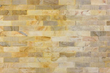 Texture of the brown wall made of square stone tile bricks 
