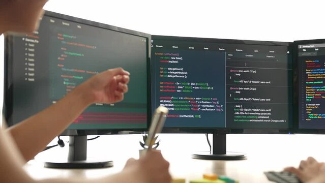 Slow motion back end software developer engineer for computer programming working together on debugging writing computing code, solving complex algorithms display on monitor in office. Burgeoning