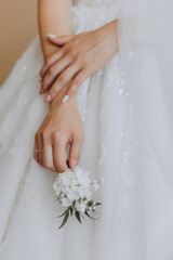 wedding boutonniere of flowers in the hands of the bride. Wedding details. The first meeting of the bride and groom. The bride is waiting for the groom.