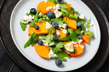 arugula persimmon cheese berries salad, top view