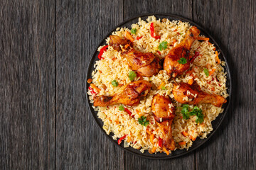 fried chicken drumsticks over rice pilaf, top view