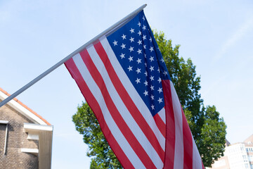 national flag of USA flutters on silk cloth against sky, 4th of July independence day concept,...