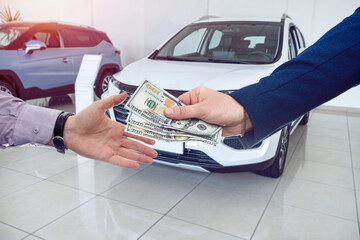 A successful purchase, the buyer gives dollars to the seller in a modern car dealership