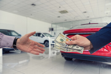 Businessman giving or paying money to dealer at modern car showroom