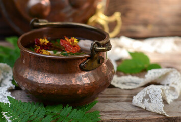 Herbal tea in a copper teapot on the table, copy space