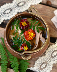 Marigold flowers in water in a copper saucepan, herbal tea, decoction of medicinal plants, close-up