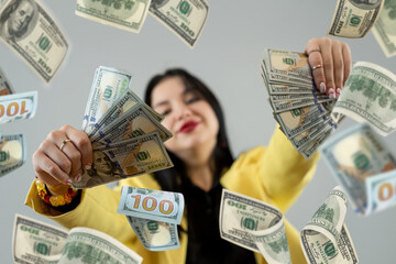 Happy caucasian woman under rain with falling down dollar cash, big win or large income