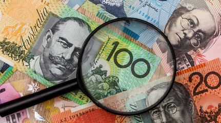australian dollar and magnifying glass. money concept