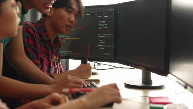 Slow motion back end software developer engineer for computer programming working together on debugging writing computing code, solving complex algorithms display on monitor in office. Burgeoning