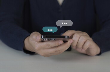 Women hand using smartphone typing Live chat chatting and social network concepts, chatting conversation working at home in chat box icons pop up. Social media marketing technology concept.