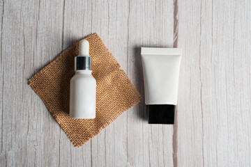 Plastic white tube for cream or lotion. Skin care or sunscreen cosmetic on white wood background.