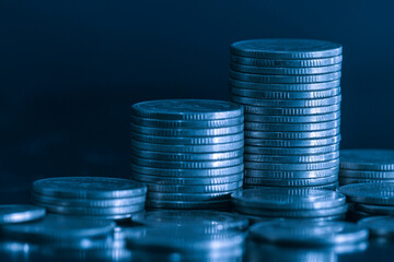 close up pile of money coin and stack on black background with blue filter. Business and finance background concept.
