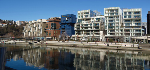 Fototapeta na wymiar Wide angle panoramic view of Antoine Riboud quay in Confluence district on a sunny winter day, Lyon, France