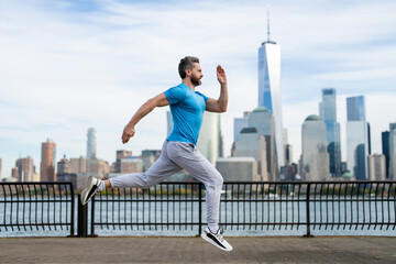 Hispanic Man runner in sport outfit run in NYC. Motion, healthy run. Jogger run near Manhattan...
