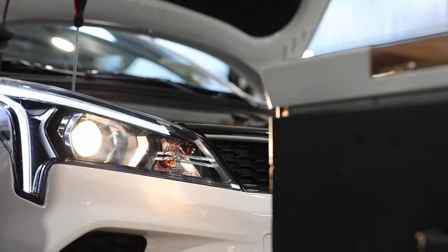 Adjusting the headlights on the car in the repair shop.