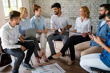 Group of young confident happy business people analyzing data during meeting in the office