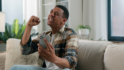 African American happy man screaming yelling smartphone achieve bet money prize victory winner guy...